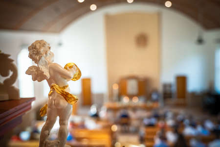 A closeup shot of a white angel statue in the church on a blurred backgroundの写真素材