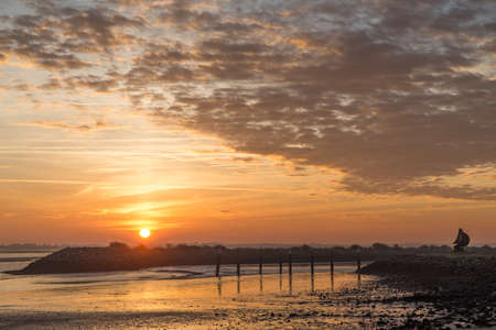 A beautiful sunset at the beach creating the perfect scenery for evening walks at the shoreの写真素材