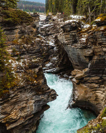 A vertical shot of a river in the middle of a mesmerizing mountainous sceneryの写真素材