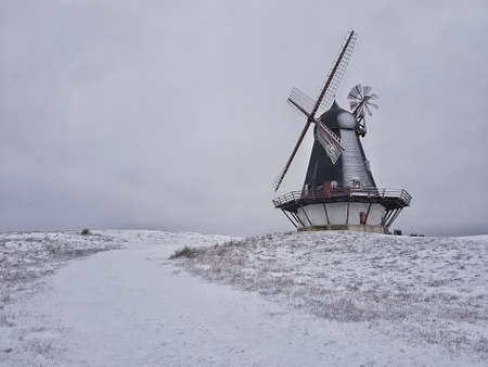 A beautiful shot of a windmill in the middle of a winter fieldの写真素材