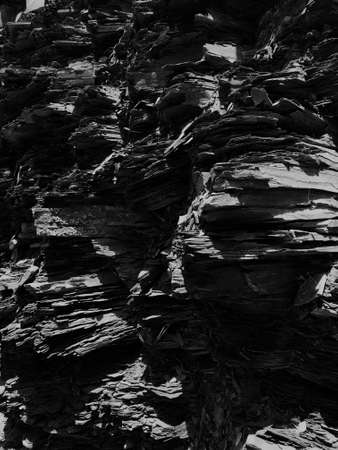 A vertical grey scale shot of beautiful layers of old rocksの写真素材