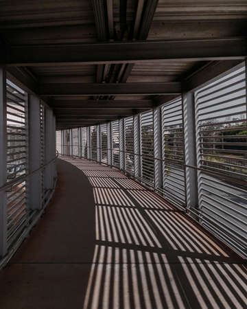 A vertical shot of windows reflecting on the floor of an indoor hallwayの写真素材