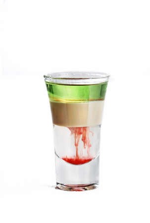 A vertical isolated shot of a multi-colored cocktail in a vodka glass  - perfect for menu usage