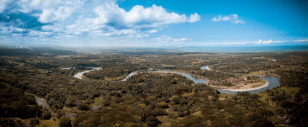 A panoramic shot of a curvy river in the middle of trees in Papua New Guinea