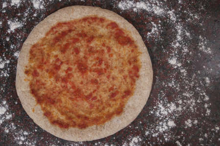 An overhead shot of pizza dough with tomato sauce and flour - great for an article about pizza...
