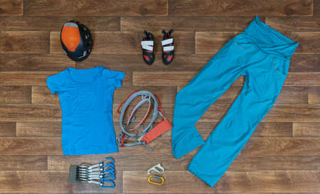 A high angle shot of mountain climbing clothes and equipment on a wooden surfaceの写真素材