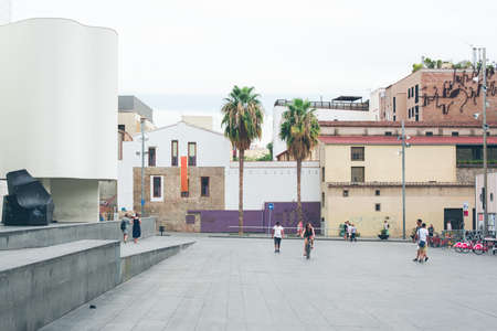 A beautiful shot of people walking around with buildings and a clear sky in the background
