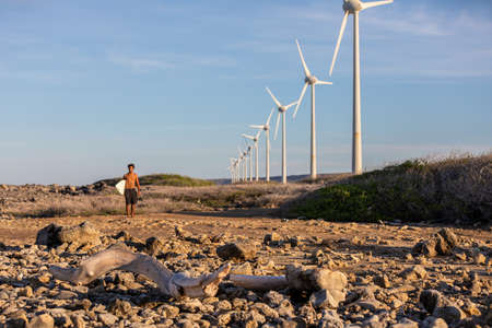 A male surfer walking to the ocean getting ready for extreme fun in Bonaire, Caribbean