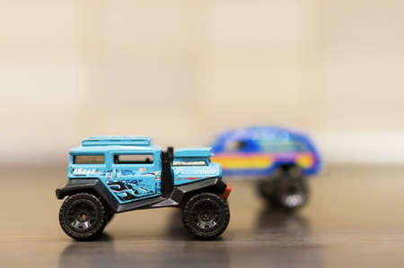 POZNAN, POLAND - Apr 18, 2017: Blue Mattel Hot Wheels dessert toy car on wooden table in soft focus