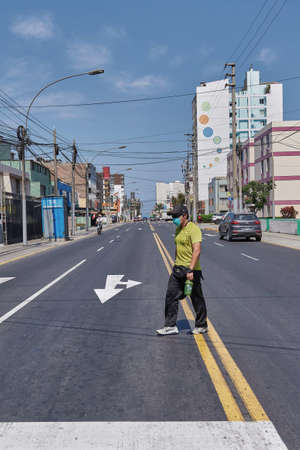 SAN MIGUEL, PERU - Apr 22, 2020: CAMINANTE CON MASCARILLA EN SOLEDAD POR CUARENTENA  COVID 19のeditorial素材