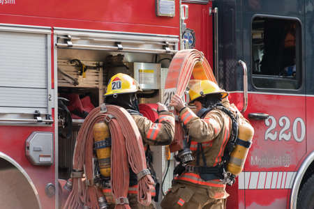 A beautiful shot of two firefighters next to the red truck getting ready for an operation