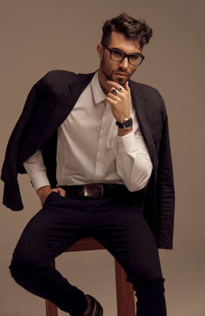 KYIV, UKRAINE - Sep 30, 2019: A vertical shot of a handsome male model with glasses wearing a suit posing for a fashion photoshootのeditorial素材