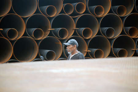 JAKARTA, INDONESIA - Mar 07, 2014: man in industrial setting with rusted pipes