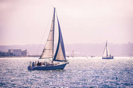A sailboat sailing around San Diego bay during a moody dayのeditorial素材