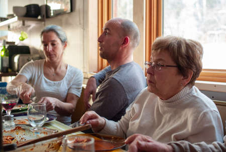WATERVILLE, CANADA - Dec 24, 2012: Waterville, Quebec / Canada - December 24 2012: Caucasian Woman, Man and Old Woman Have Lunch at the Table Looking Boredのeditorial素材