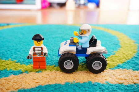POZNAN, POLAND - Jun 22, 2017: Lego police officer with helmet sitting in a four wheel scooter