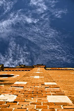 A low angle vertical shot of a brick building with a blue sky in the backgroundのeditorial素材