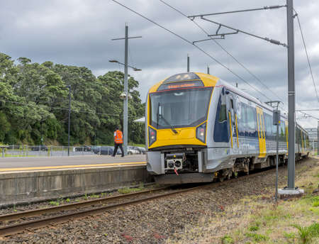 AUCKLAND, NEW ZEALAND - Dec 12, 2015: A low angle shot of a yellow train under the storm clouds in...