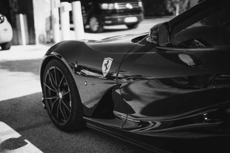 SAINT TROPEZ, FRANCE - Aug 01, 2019: A closeup grayscale photography of a Ferrari coupe supercar parked on cementのeditorial素材
