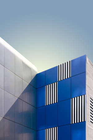 A vertical low angle shot of a modern building under the blue skyの写真素材