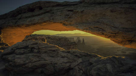 A scenery of a breathtaking vibrant sunset taken from the open middle of a rock formation