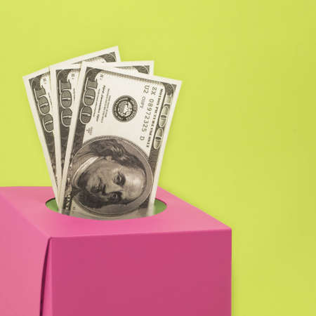 A closeup shot of money in a pink box on a green backgroundの写真素材