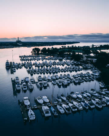 A high angle view of white ships on a river surrounded by greenery and towns during sunset