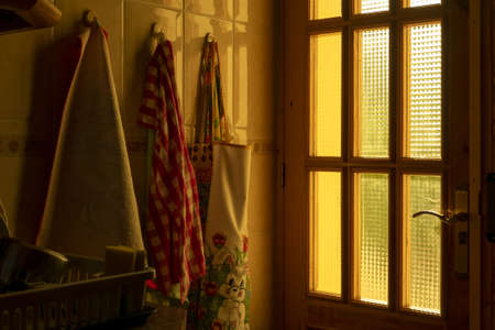 A kitchen interior with towels hanging on the wall