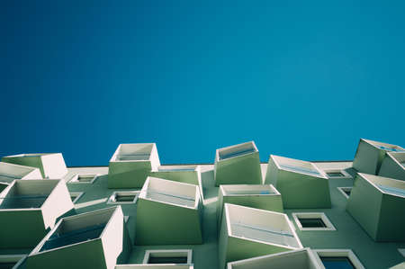 A modern building with unique windows touching the clear blue skyの写真素材