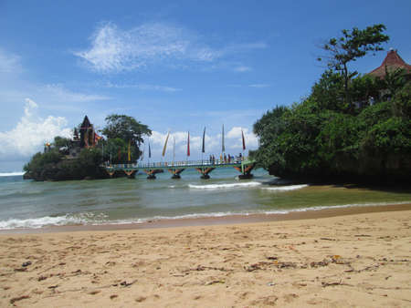 A beautiful beach and two small islands connected by a bridgeの写真素材