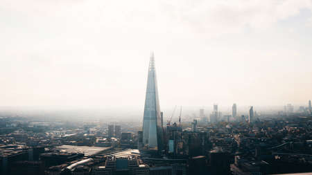 A wide distant shot of the Shard skyscraper surrounded by buildings  in London, Englandのeditorial素材