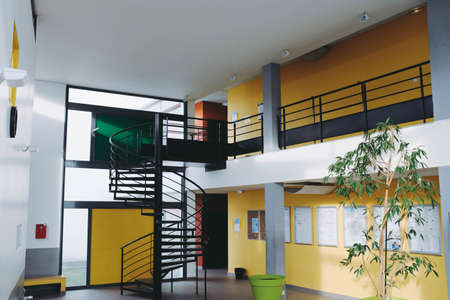 A modern interior with black handrails colorful walls and a wooden floor under white lamps