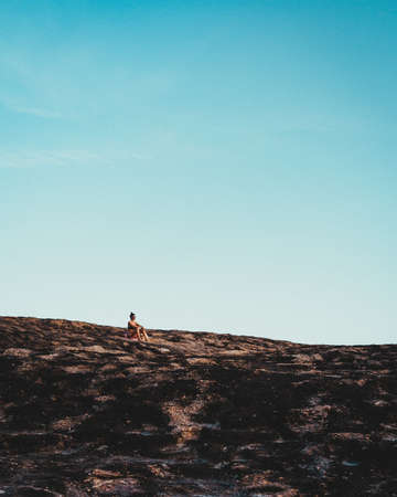 RIO DE  JANEIRO, BRAZIL - Jul 21, 2019: Lonely girl watching the sunset on a mountain.のeditorial素材