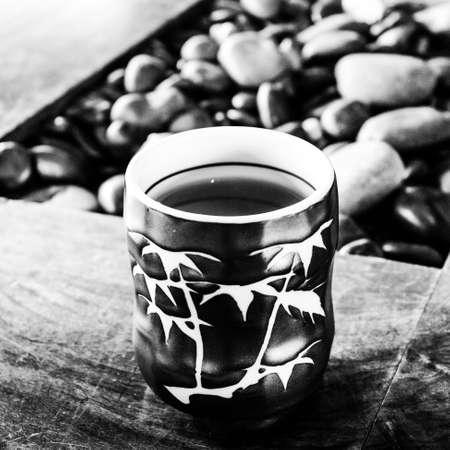 A grayscale shot of a mug filled with coffeeの写真素材