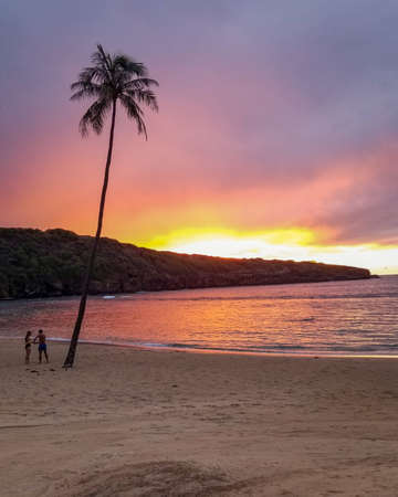 A vertical shot of a breathtaking sunset over the ocean at the tropical beachの写真素材