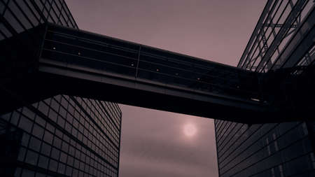 A low angle view of a modern building with glass walls under a cloudy sky during sunset