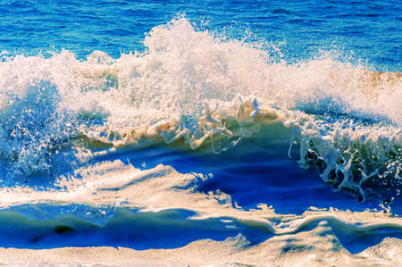 A beautiful shot of calming and splashing ocean waves on a sunny day