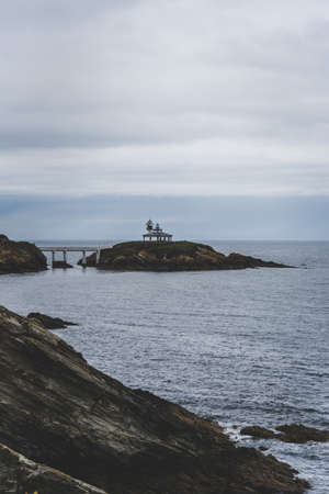 The Isla Pancha island surrounded by the sea under a cloudy sky during daytime in Spain
