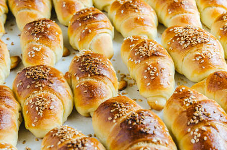 A closeup shot of delicious small croissants taken out from the oven - perfect for a food blog