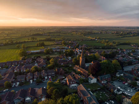 A high angle shot of buildings surrounded by trees under a cloudy skyの写真素材