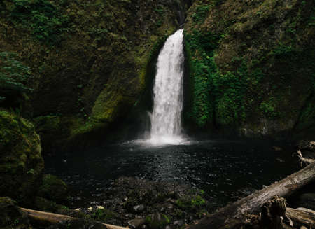 A beautiful small waterfall in the center of the mossy rocks