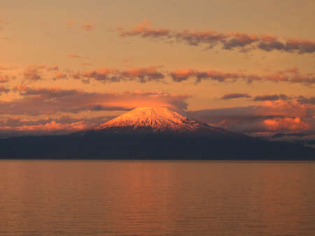 A sunset over the mountain at the ocean shore