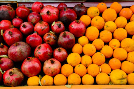 A lot of pomegranates and oranges in a fruit market - great for a cool background