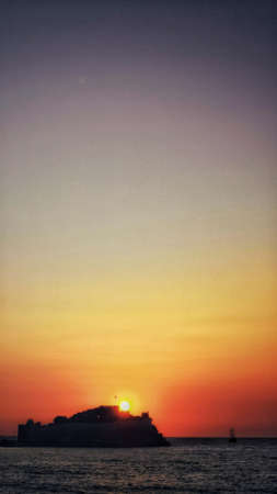 A vertical shot of a breathtaking sunset over the oceanの写真素材