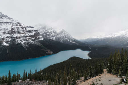 A high angle shot of a clear frozen lake surrounded by a mountainous sceneryの写真素材
