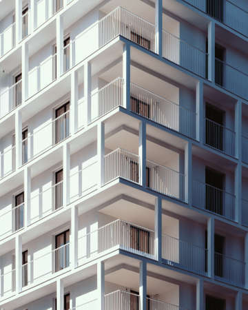 A vertical low angle shot of a high rise white concrete building