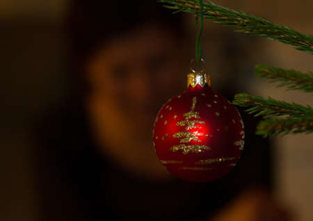 A closeup shot of a red Christmas ornament hanging off the treeの写真素材