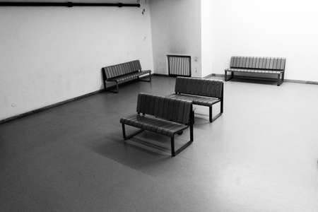 A greyscale of chairs in a room with white walls under sunlight during daytimeの写真素材