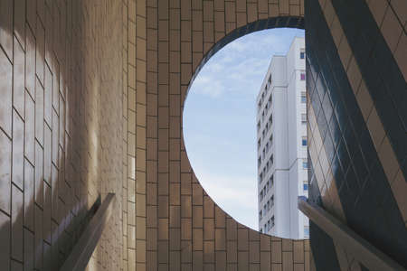 A white building visible from the round window in a tiled building