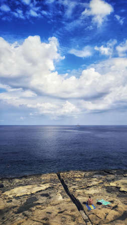 A vertical shot of the marvelous calm ocean during the evening timeの写真素材
